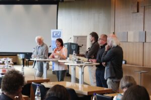 Mehrere Personen sprechen auf der Bühne